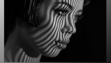 A Striking Black And White Image Of A Woman'S Face With Short Hair Illuminated By Striped Shadows. The Shadows Create A Pattern Over Her Face. The Text &Quot;Infinite Black &Amp; White V1.0.1 Cracked&Quot; Appears At The Bottom Along With An Infinity Symbol.